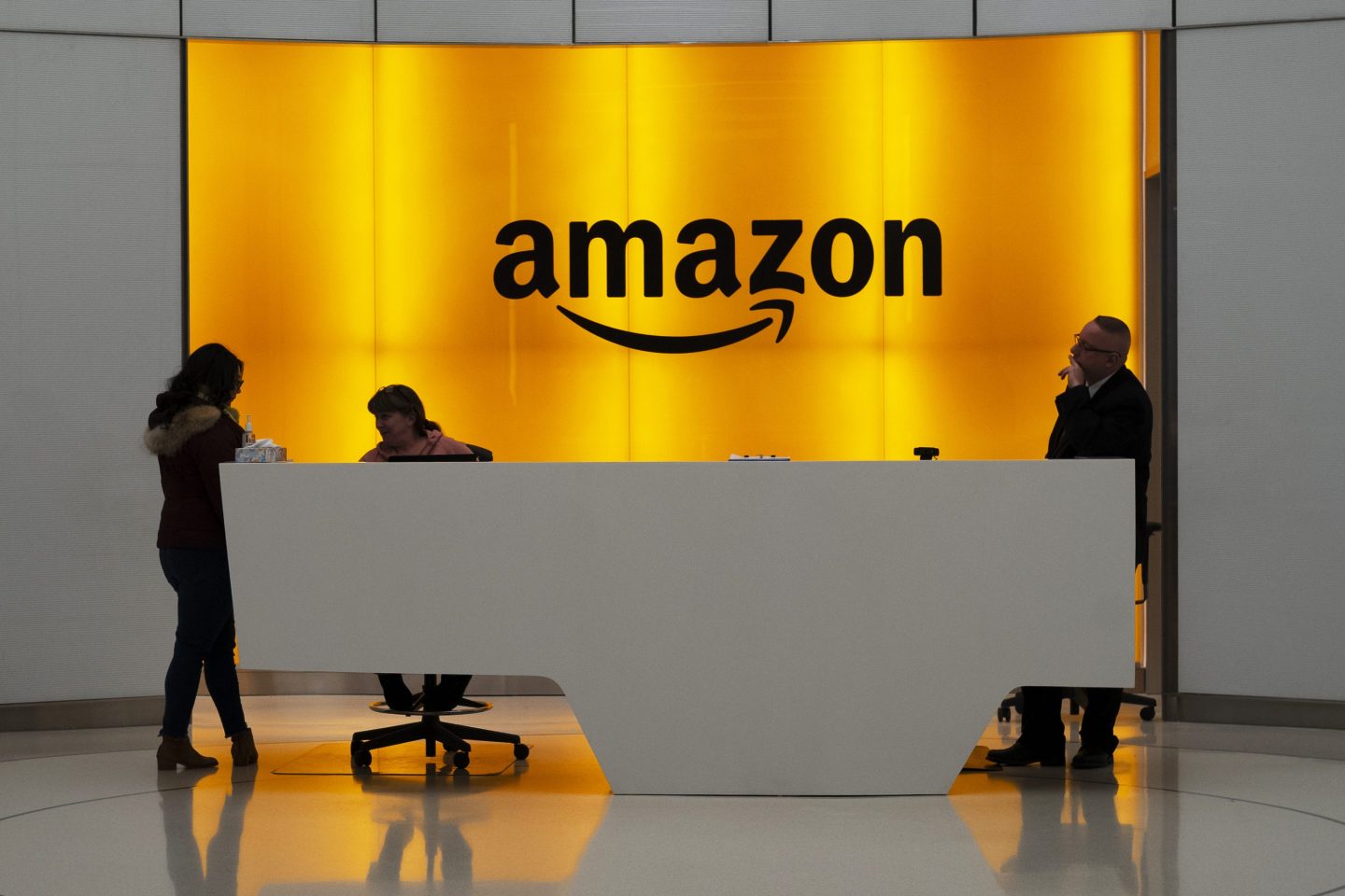 People stand in the lobby for Amazon offices in New York.