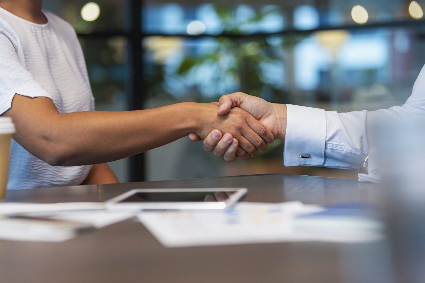 Business man and woman shaking hands in the office.