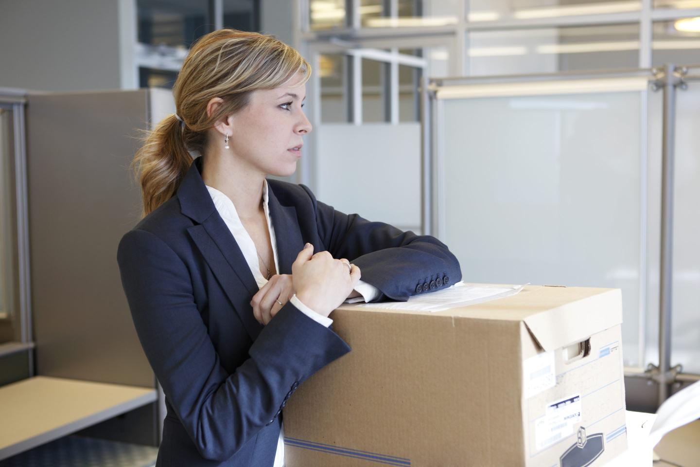 Woman with moving boxes in office