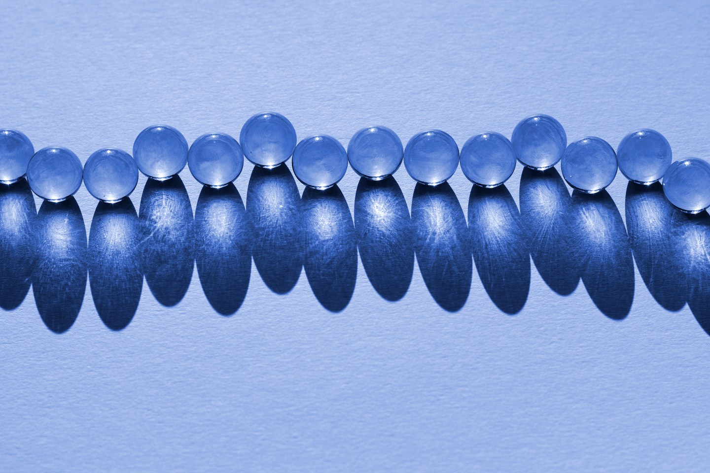 Crystal balls lined up in a single line with a deep shadow.