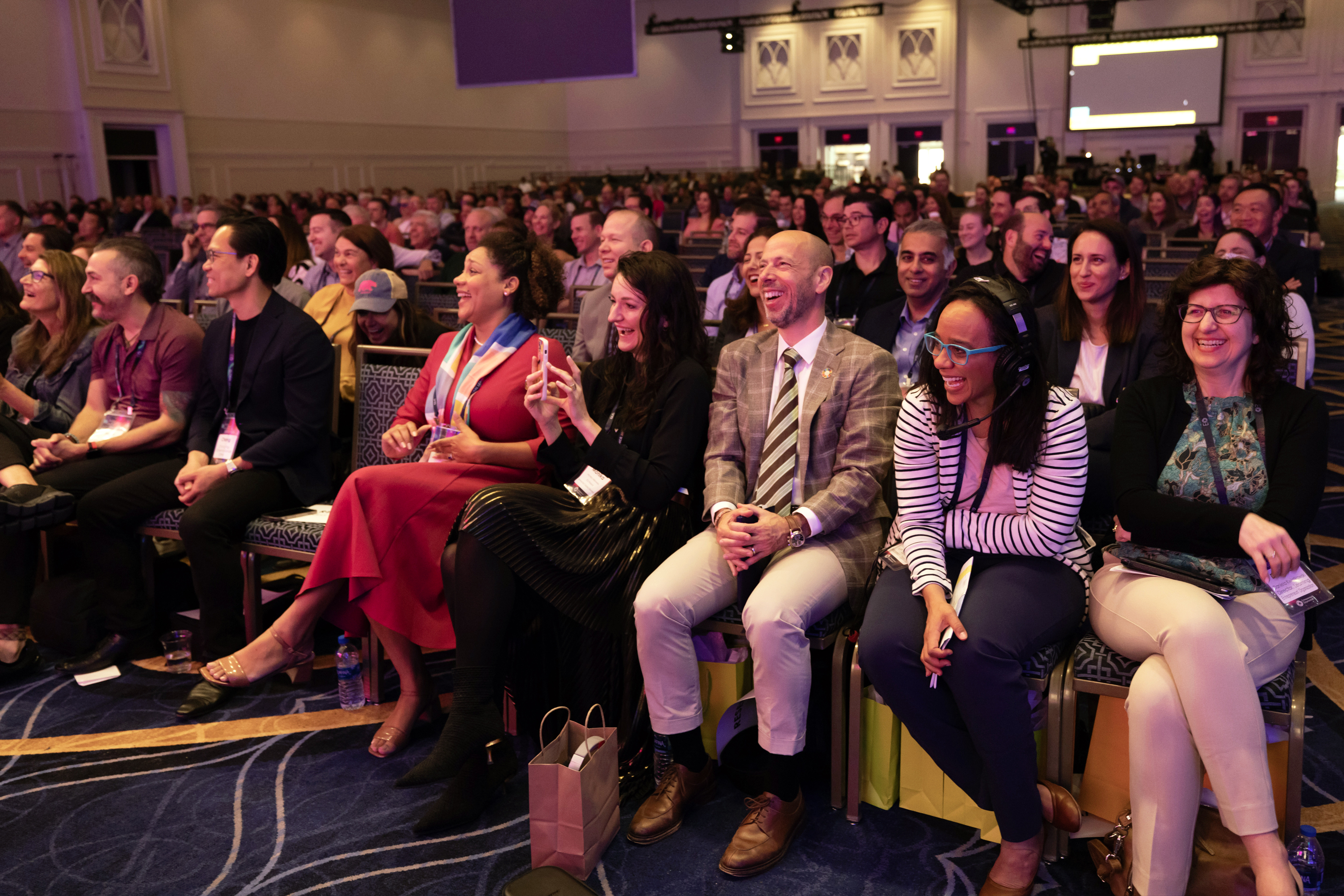 Photo of an audience laughing during a presentation for startup founders
