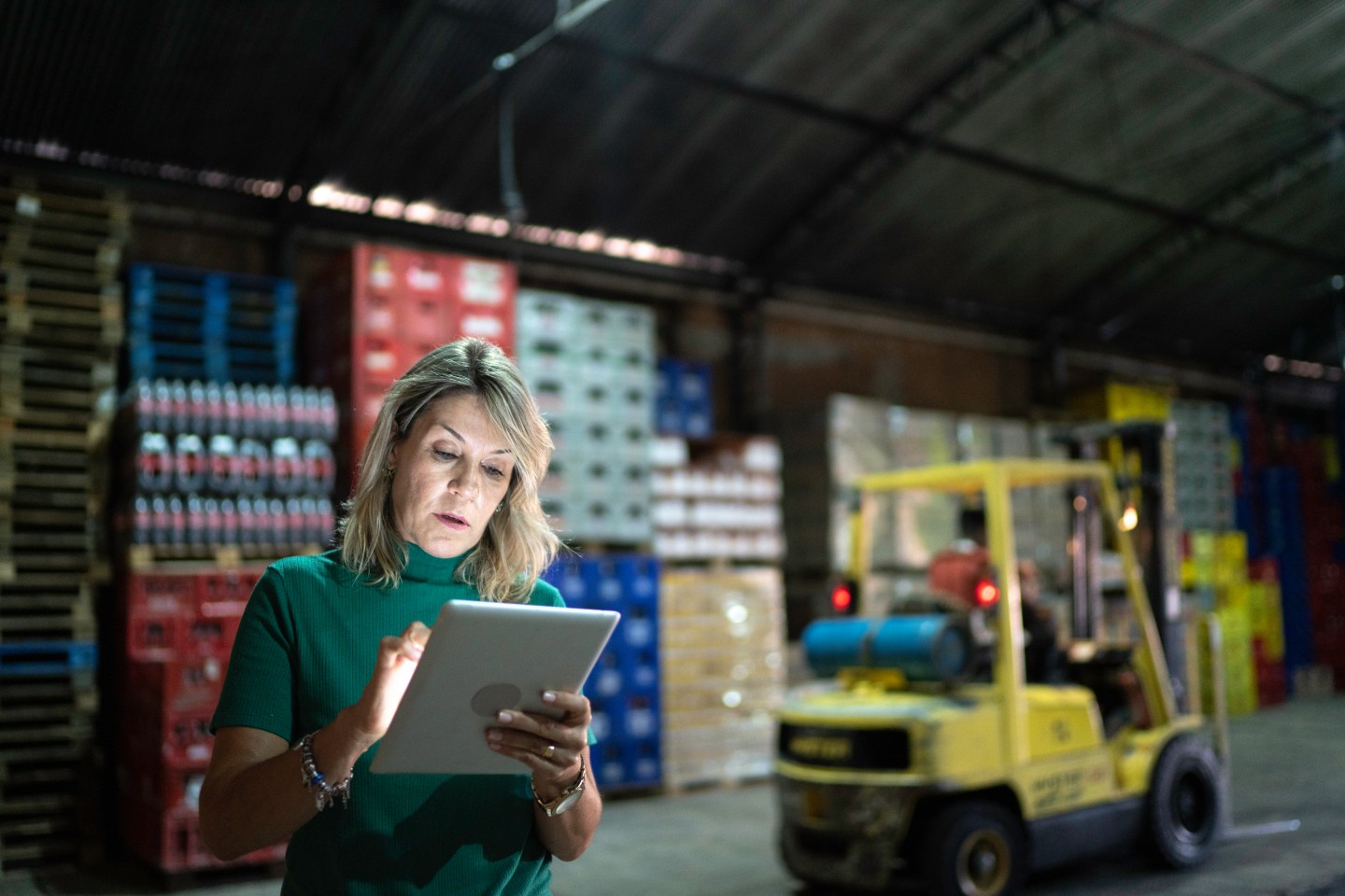 A woman looking at a tablet in a warehouse.