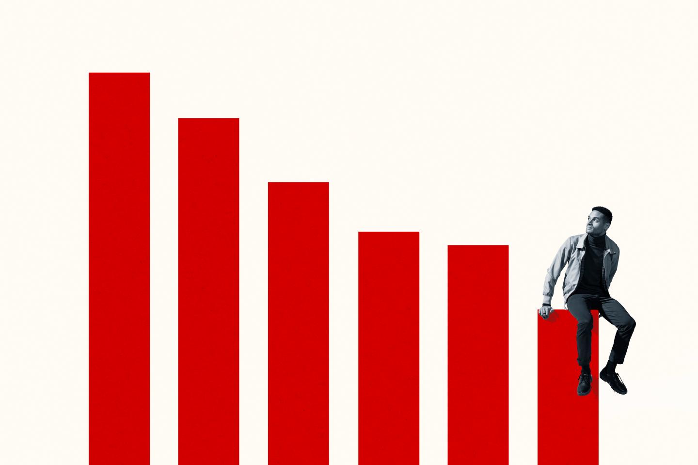 Full length of young man sitting on bottom graph bar while looking up against white background