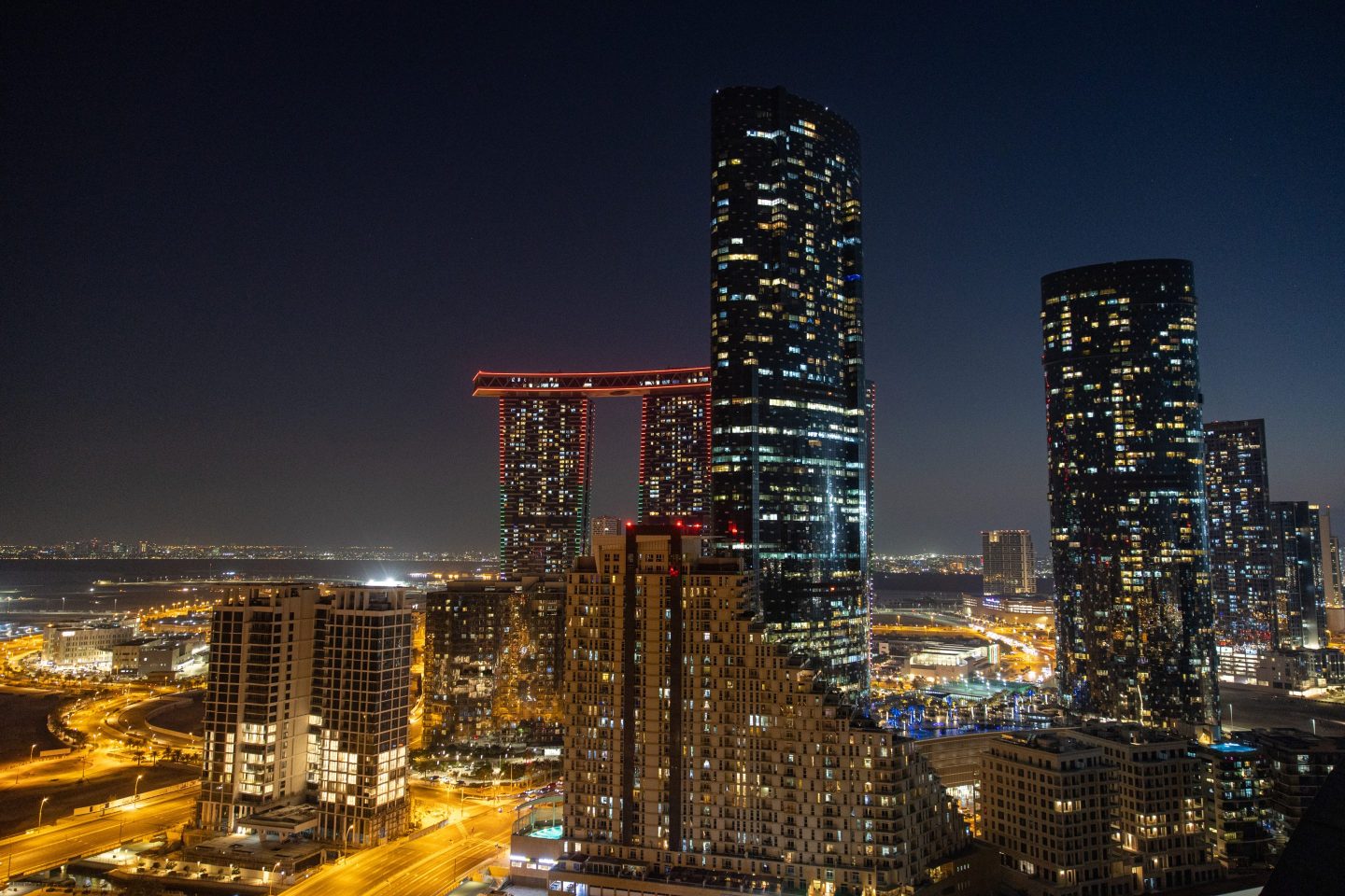Residential high-rise buildings at night in the Al Reem district of Abu Dhabi, United Arab Emirates, on Thursday, Nov. 24, 2022.