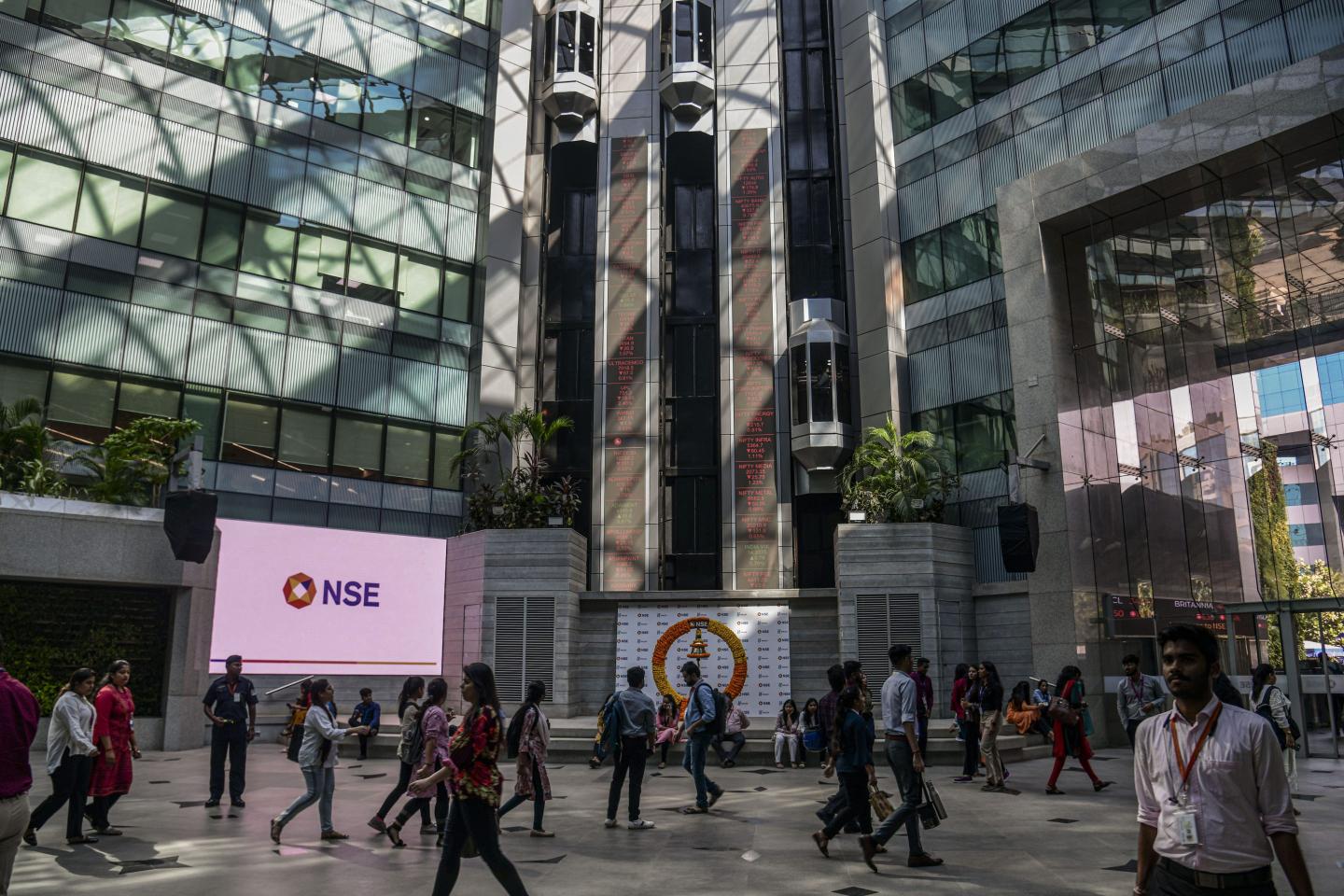 Workers walk in the atrium of the National Stock Exchange of India Ltd. (NSE) building in Mumbai, India, on Tuesday, Dec. 20, 2022.