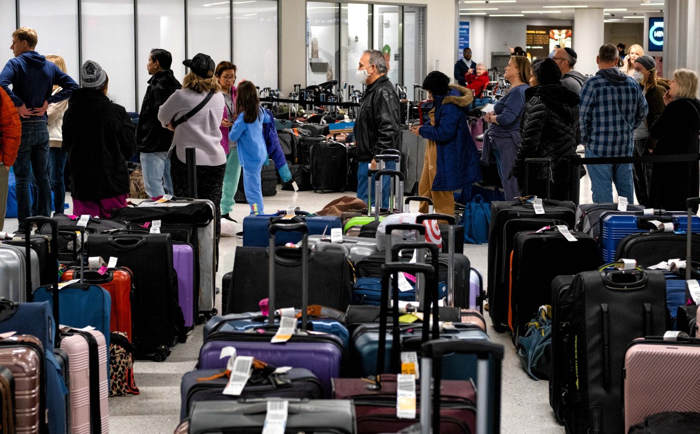 Passengers wait in line to claim their baggage at Nashville International Airport
