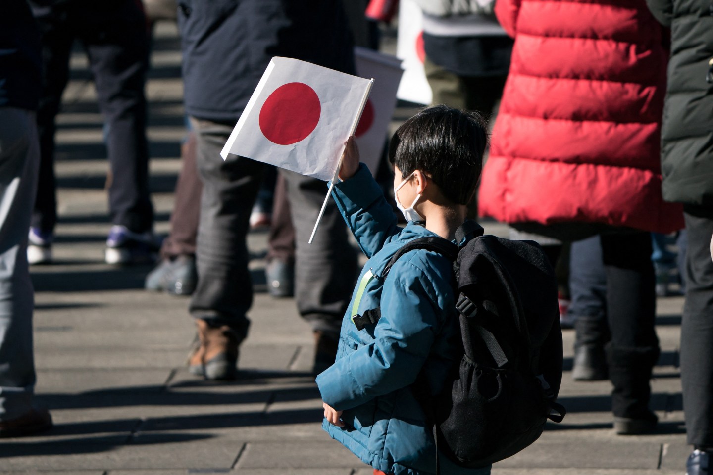 A young boy is pictured in Tokyo on New Year's Eve, 2022, waving a Japanese flag.