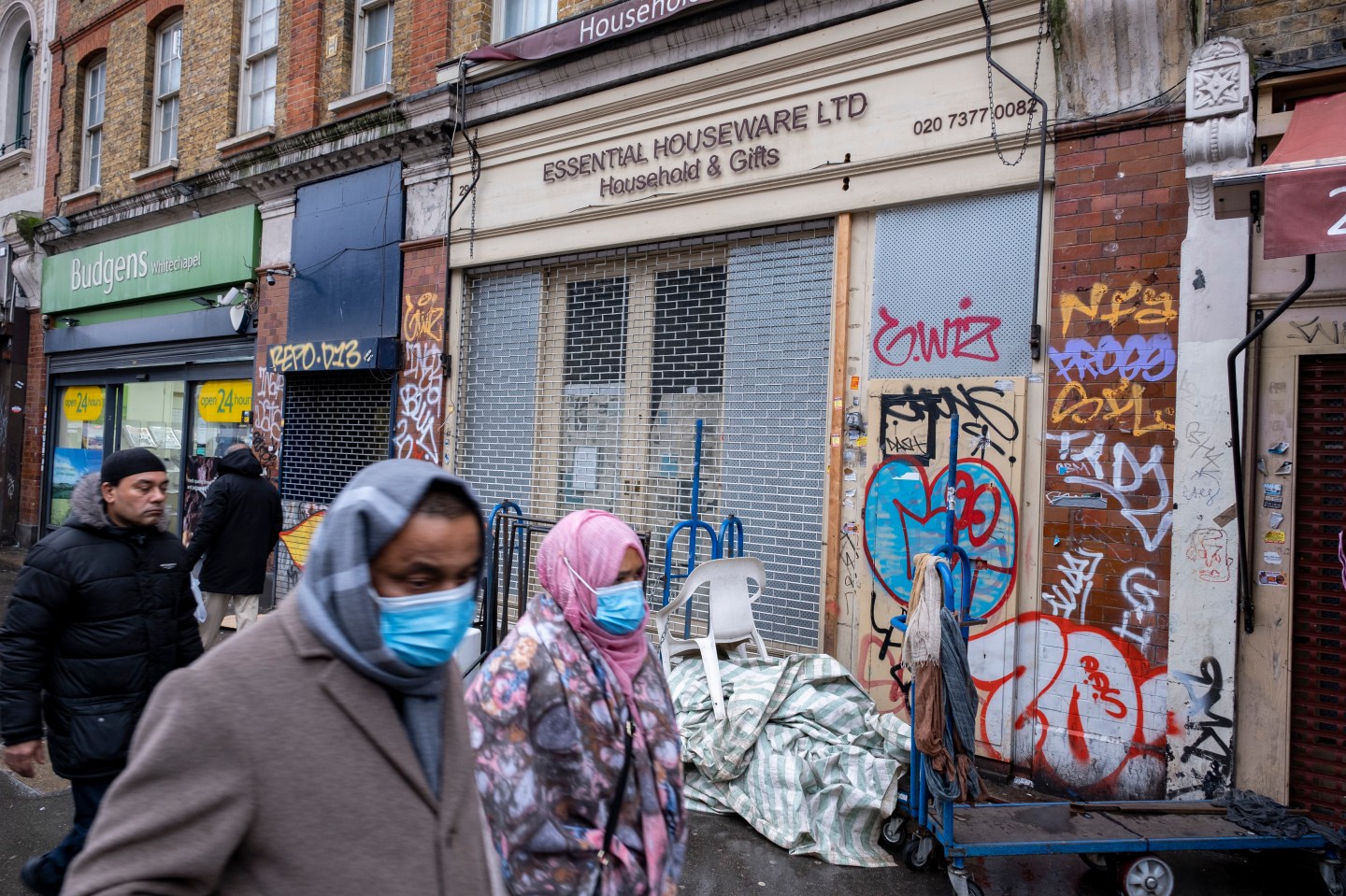 People walking in front of closed retail spaces in London