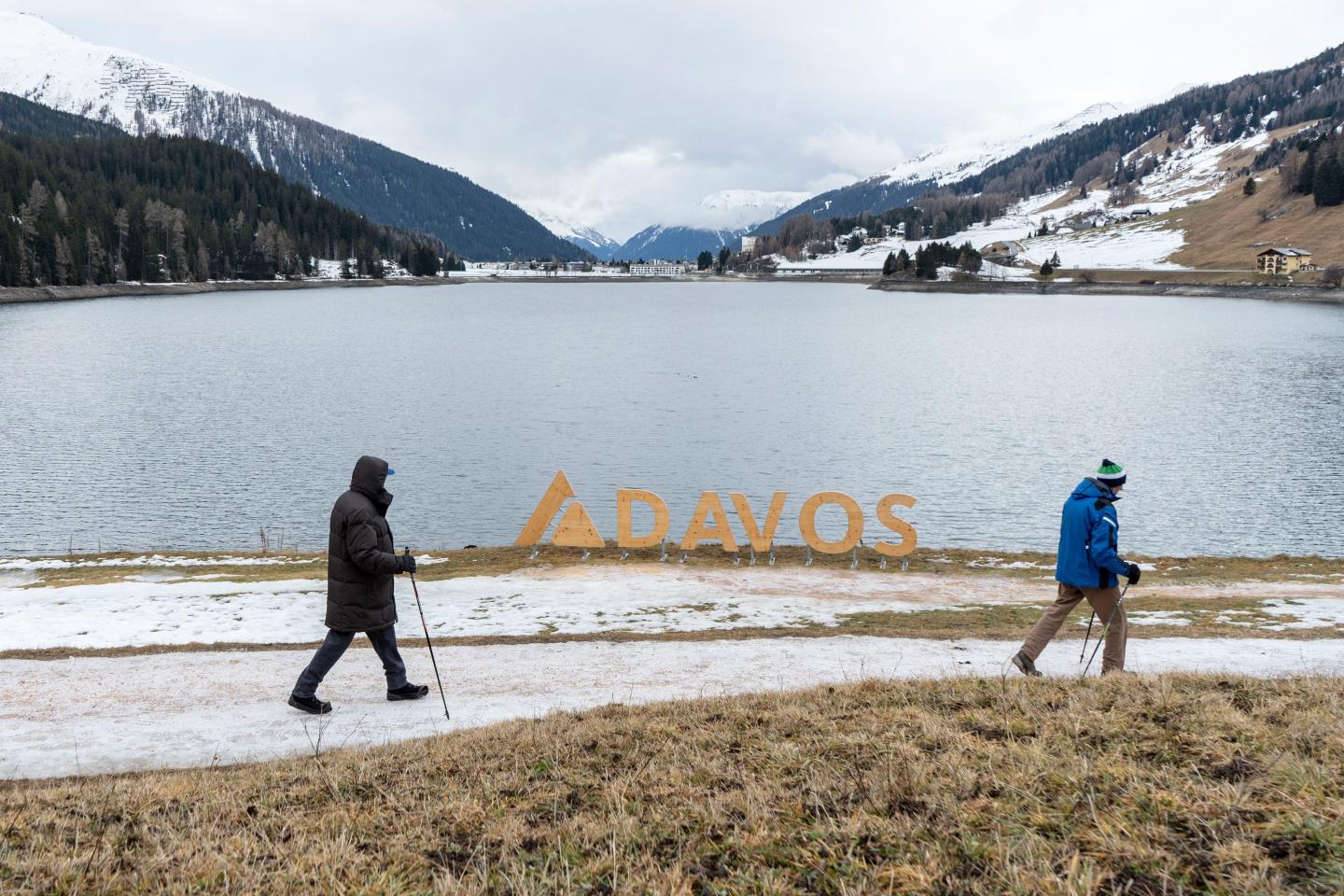 Walkers on a trail of thinning snow around Lake Davos in Davos, Switzerland, on Jan. 8, 2023. 