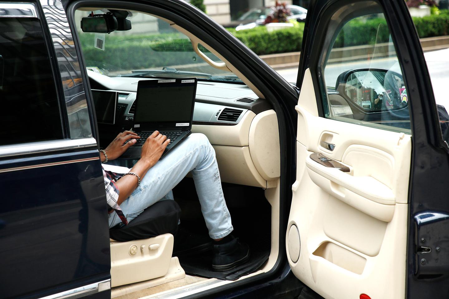 Man in car with laptop