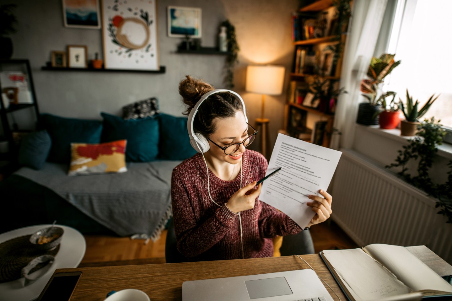 A woman in headphones teaches a class online