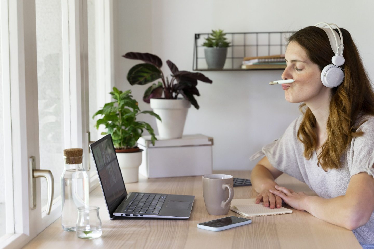 Woman balancing a pen on her own during a virtual meeting on her laptop at home