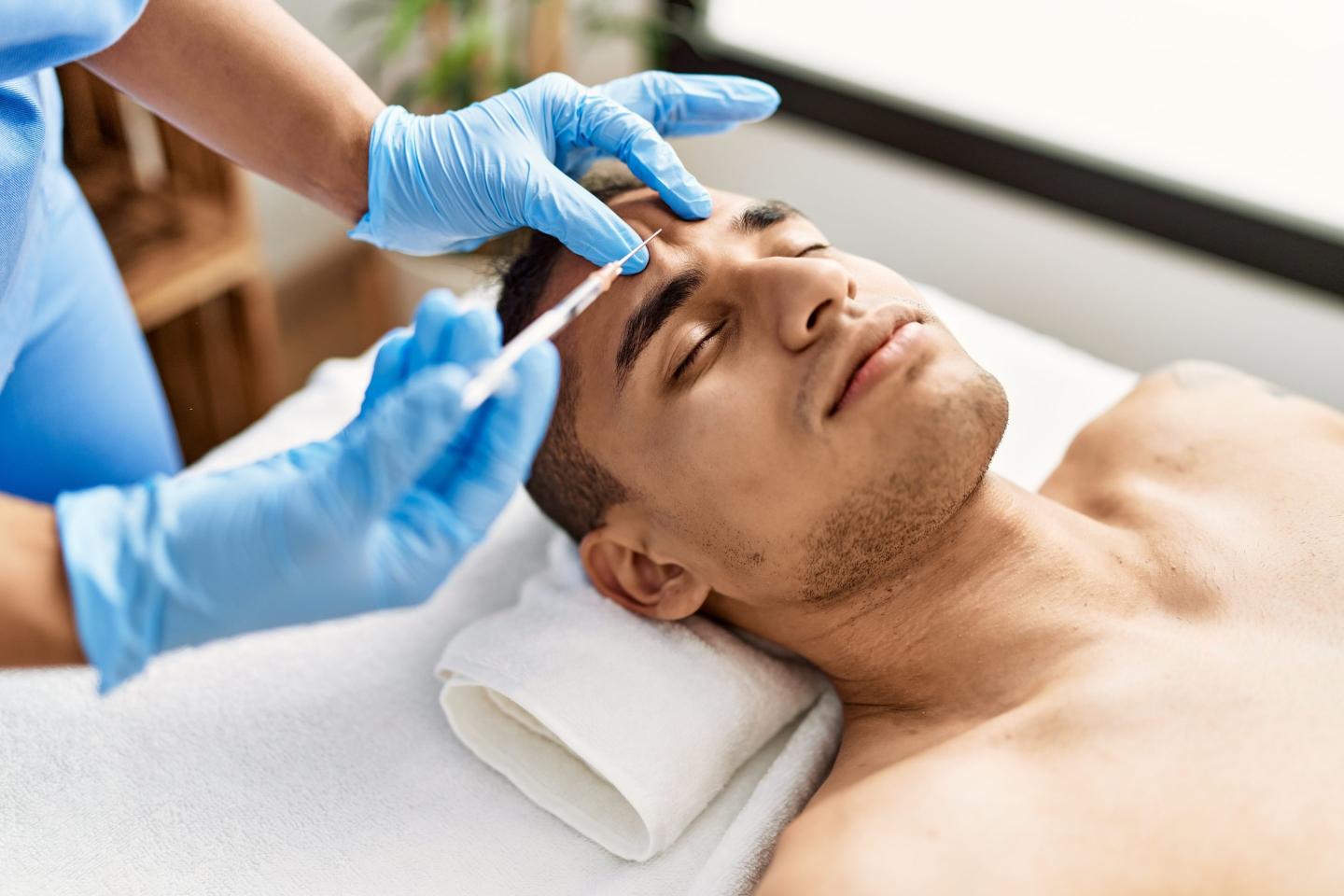 Doctor injecting botox on man face