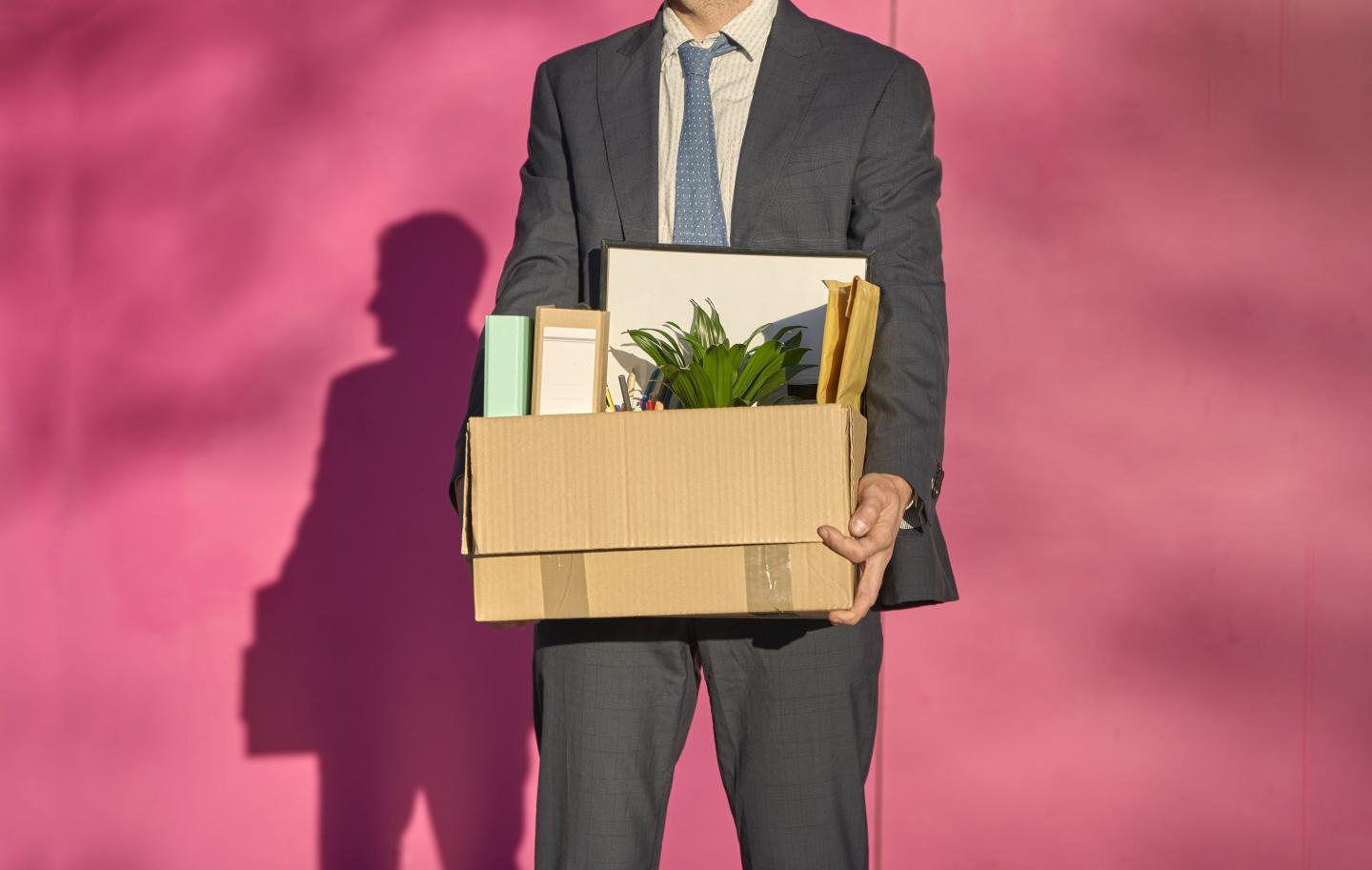 Businessman carrying box with personal belonging on sunny day