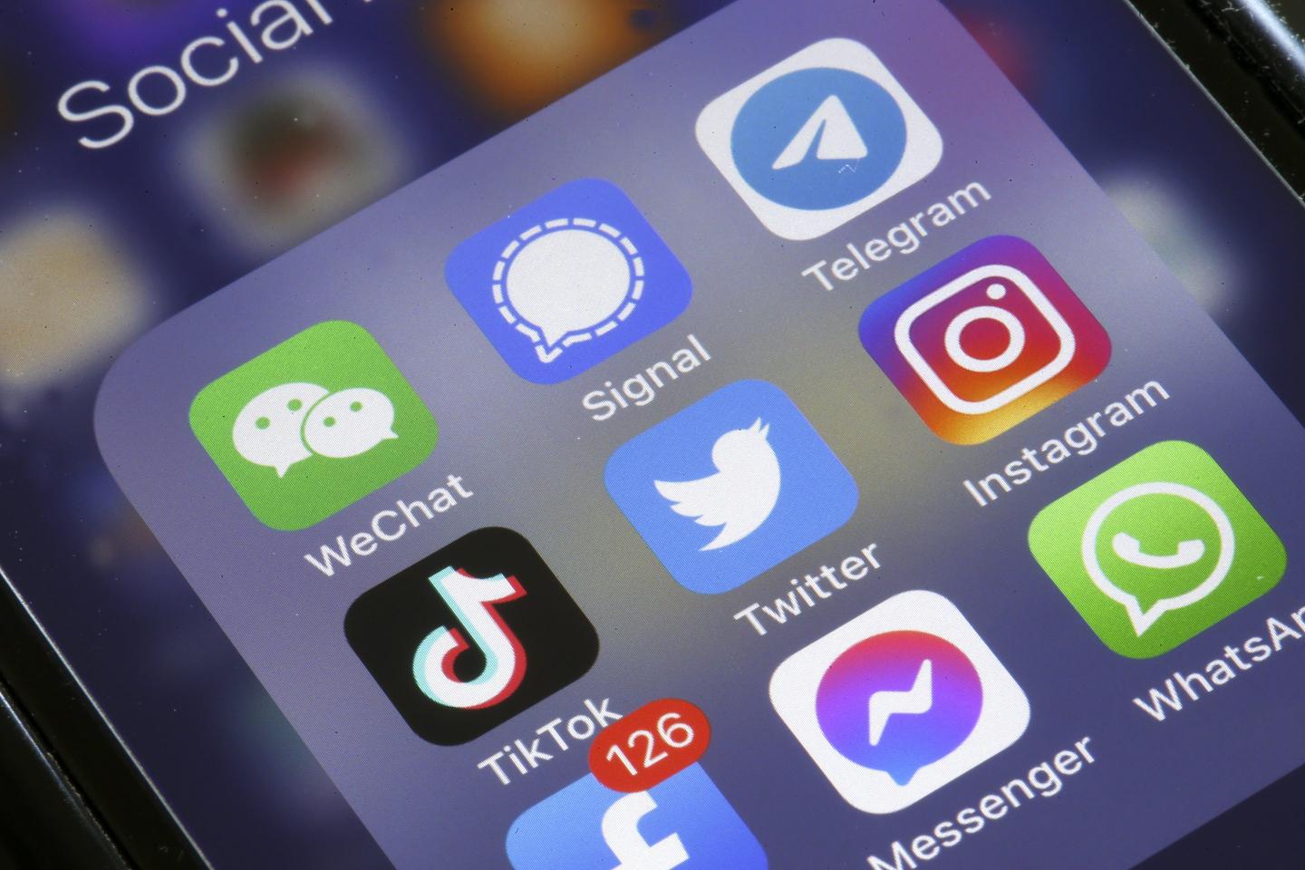 the logos of social media applications, Instagram, WhatsApp, Messenger, WeChat, Signal, Telegram, TikTok, Twitter and Facebook are displayed on the screen of an iPhone