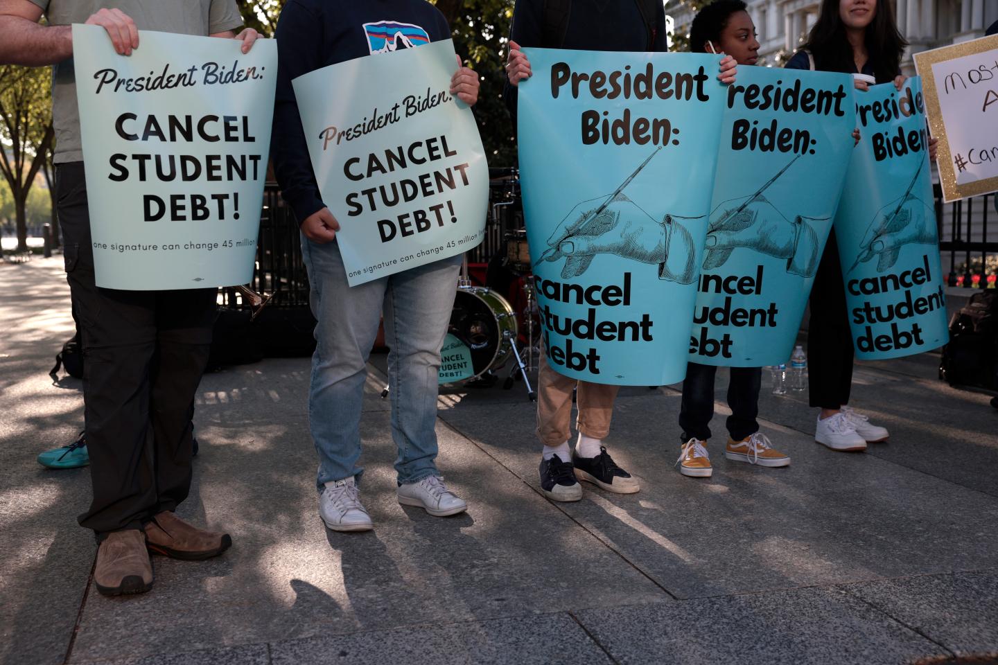 Student debt protesters holding signs.