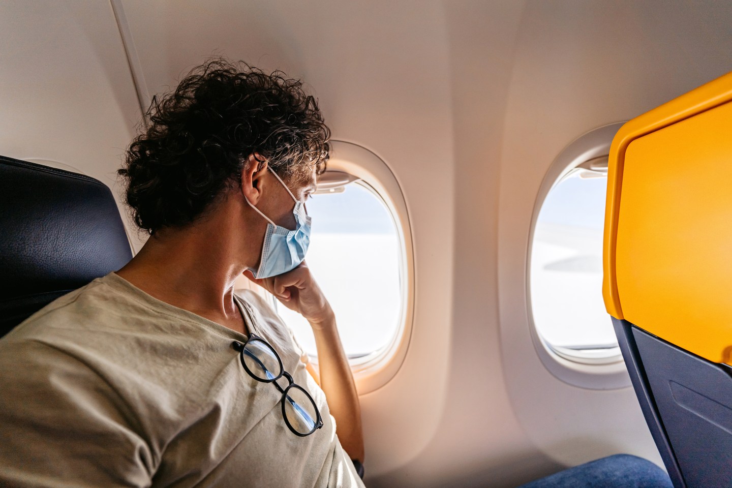 man looking out airplane window
