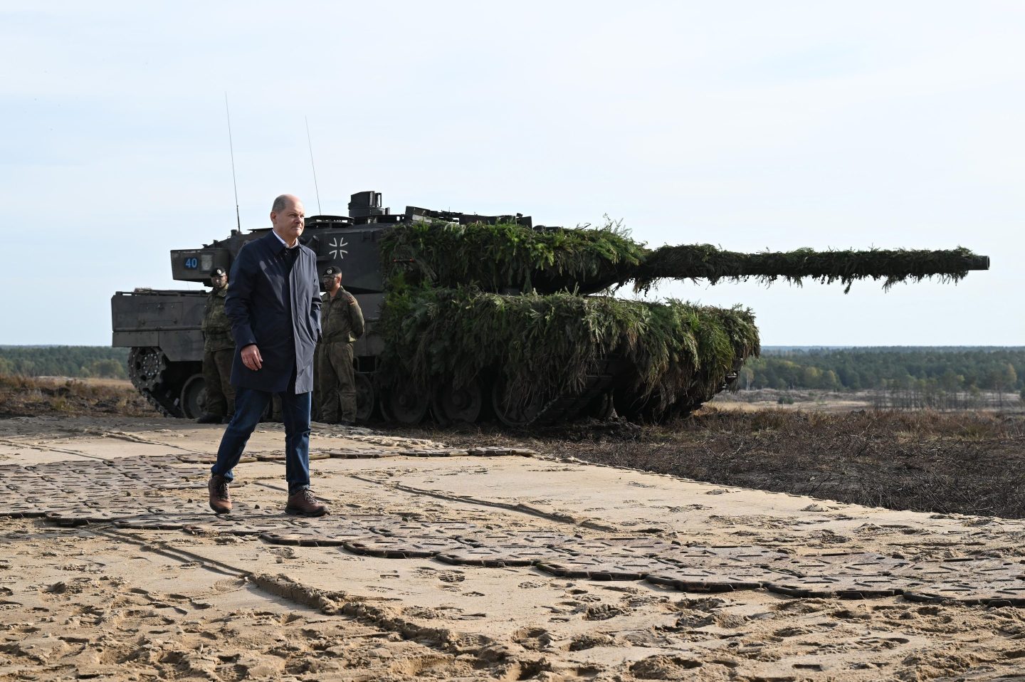 German Chancellor Olaf Scholz walks past a Leopard 2 main battle tank of the Bundeswehr while visiting the Bundeswehr army training center in Ostenholz on October 17, 2022 near Hodenhagen, Germany.