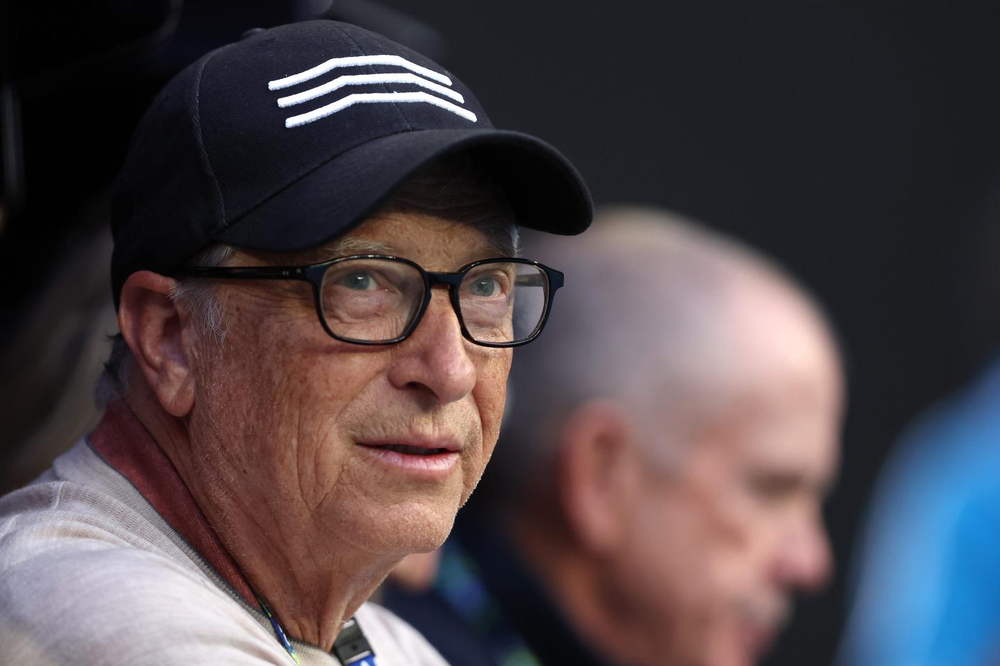 Bill Gates wearing a black baseball cap at the 2023 Australian Open