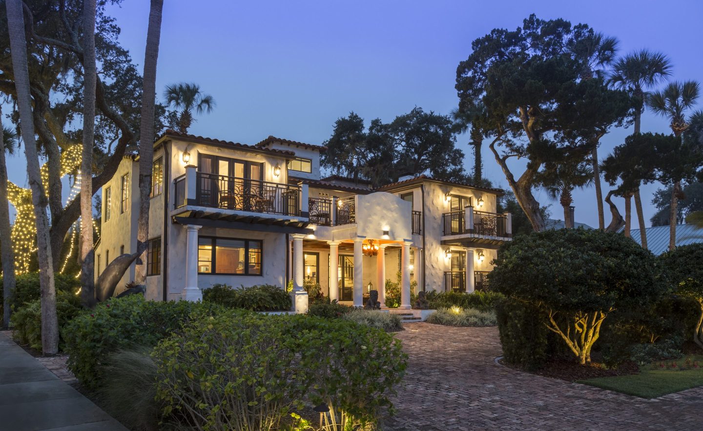 A grand house is illuminated at twilight
