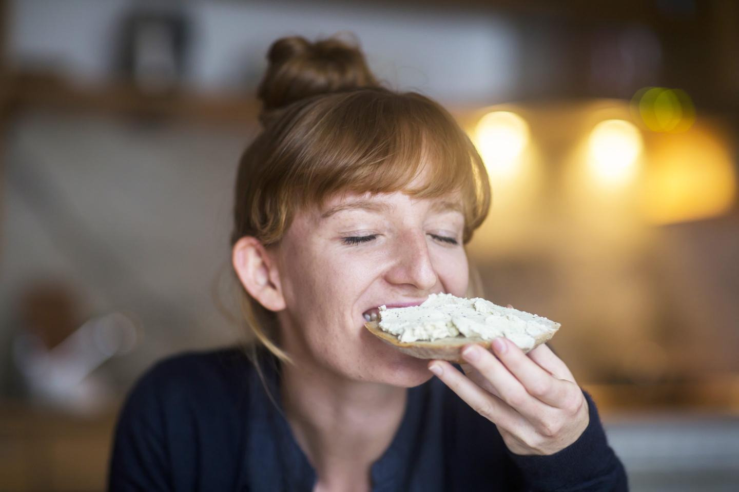 Woman looks happy while eating cheese