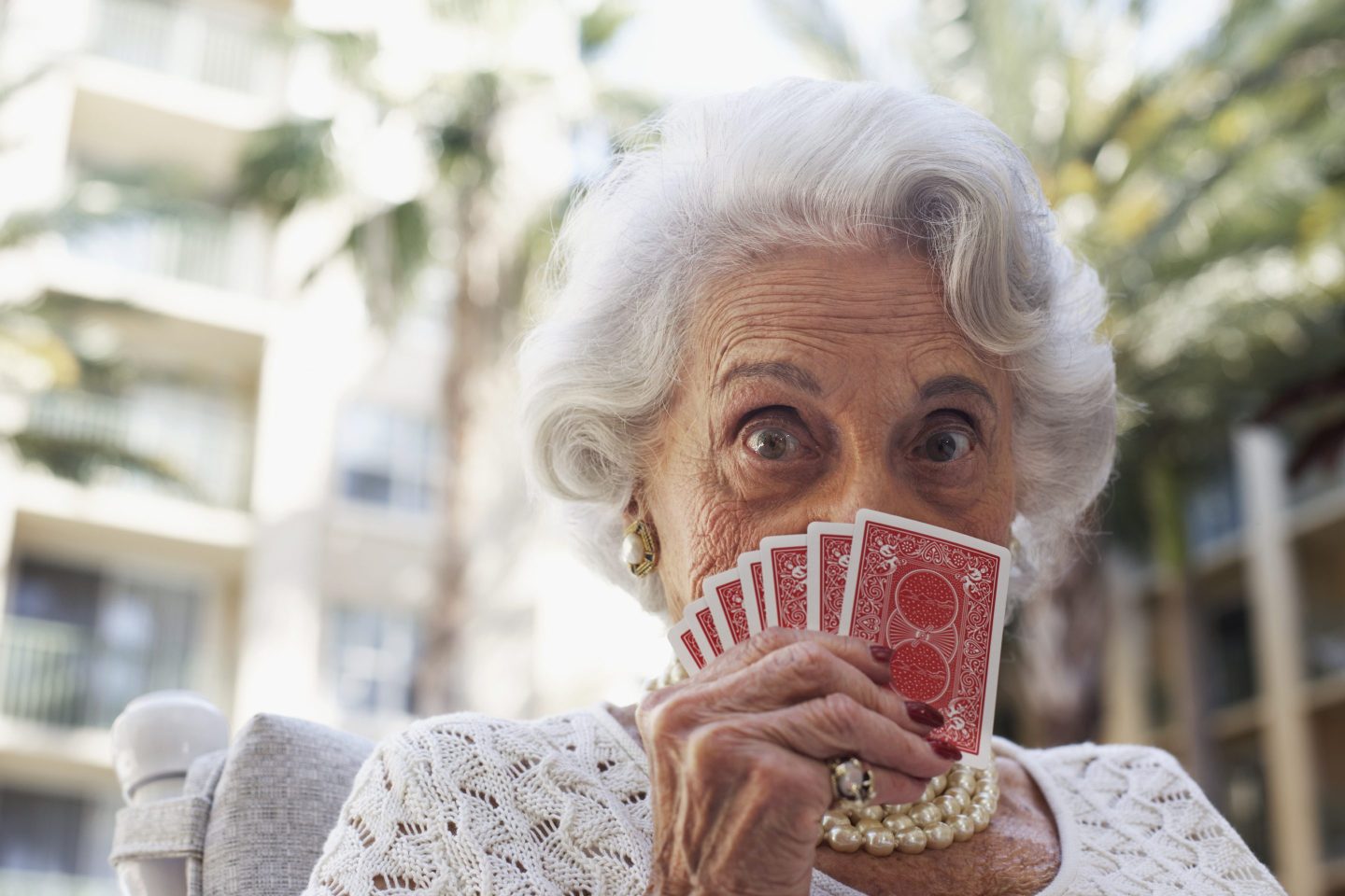 A senior woman plays cards.