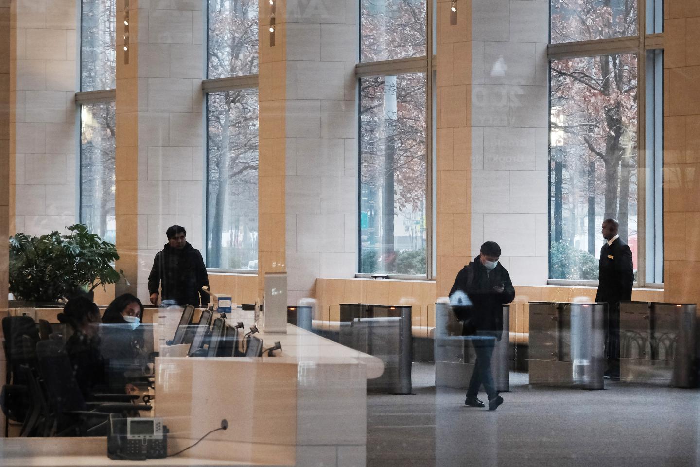 People walk through the lobby of the Goldman Sachs headquarters in Manhattan on December 16, 2022.