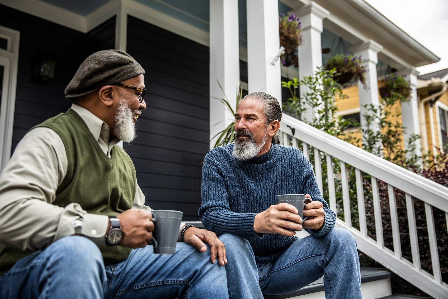 Senior men having coffee in front of suburban home.