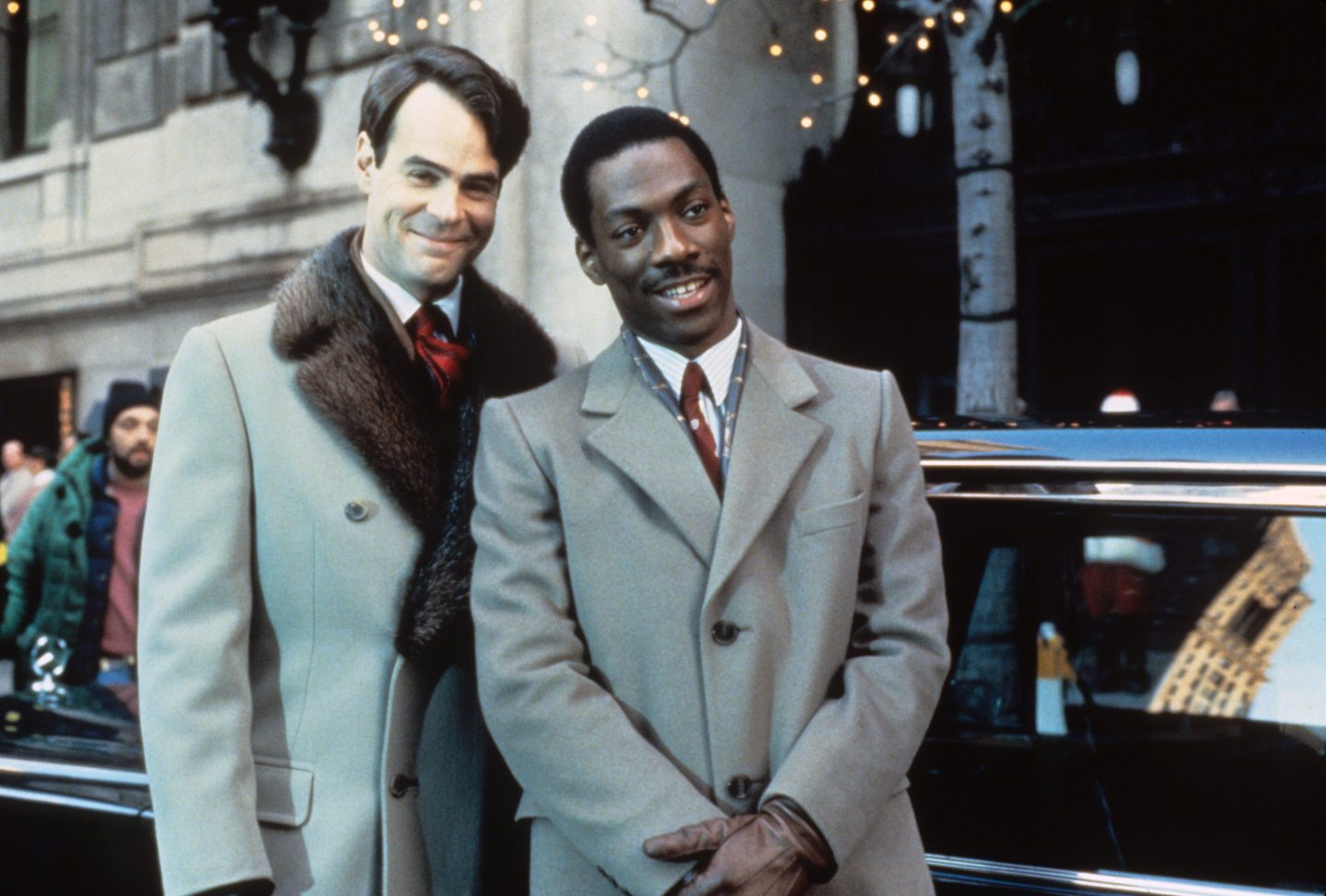 Dan Aykroyd and Eddie Murphy, smiling and wearing overcoats, in a photo for the movie Trading Places.