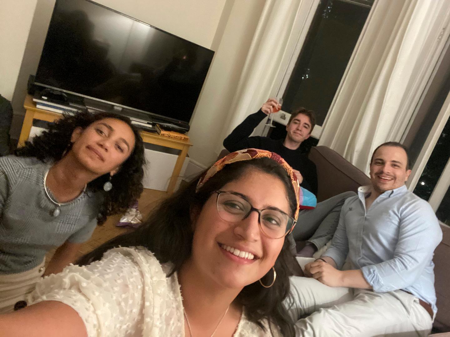 Four friends who met through work sitting in a living room.