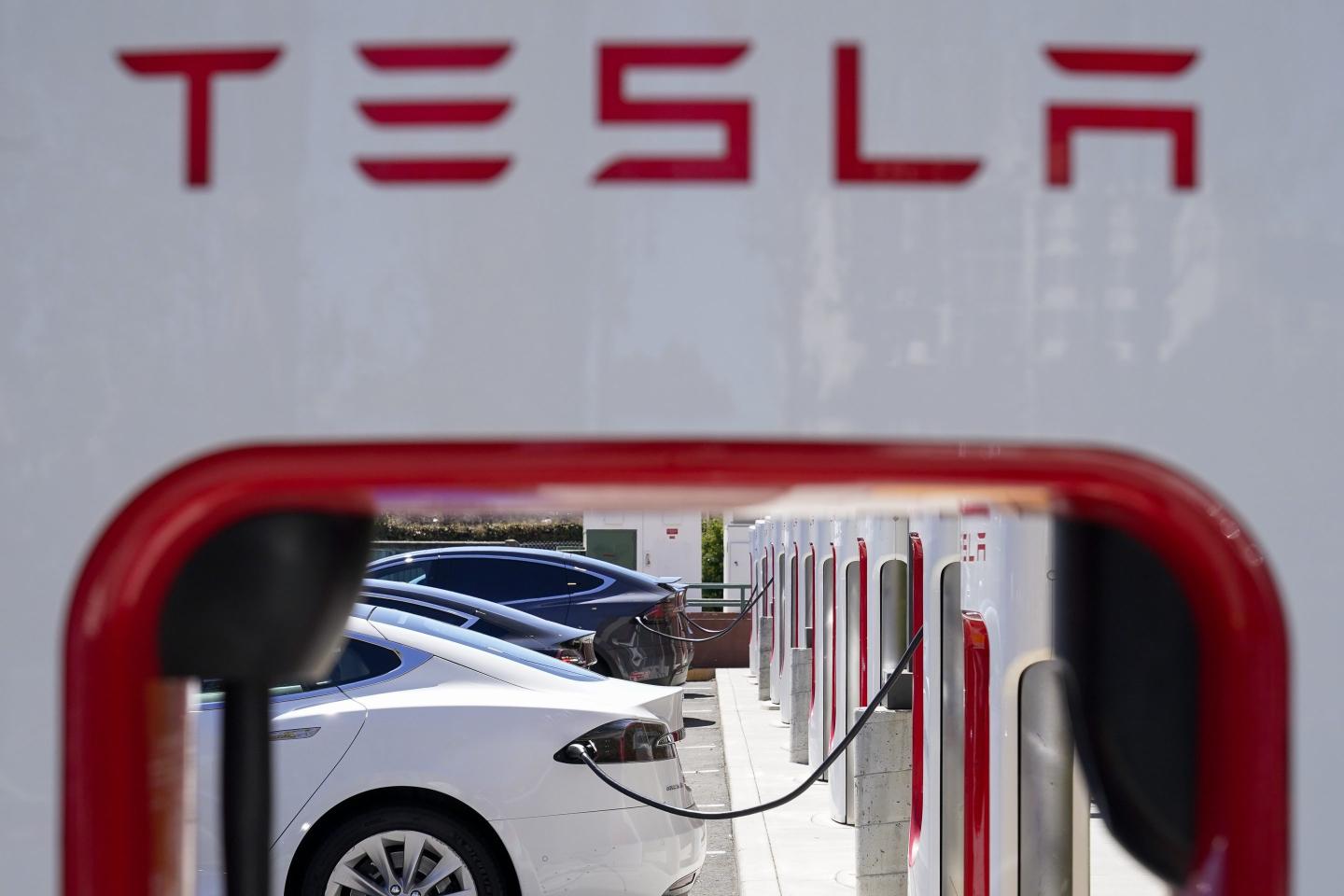 Tesla vehicles charge at a station in Emeryville, Calif., Aug. 10, 2022. 