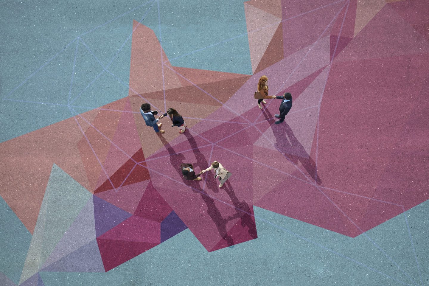 Businesspeople making handshakes, while standing on painted pattern on asphalt