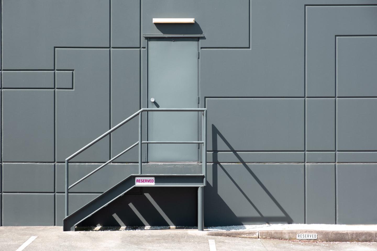 Rear Entrance Door With Metal Stairs Into Industrial Building - Minimal Clean Geometric Shapes