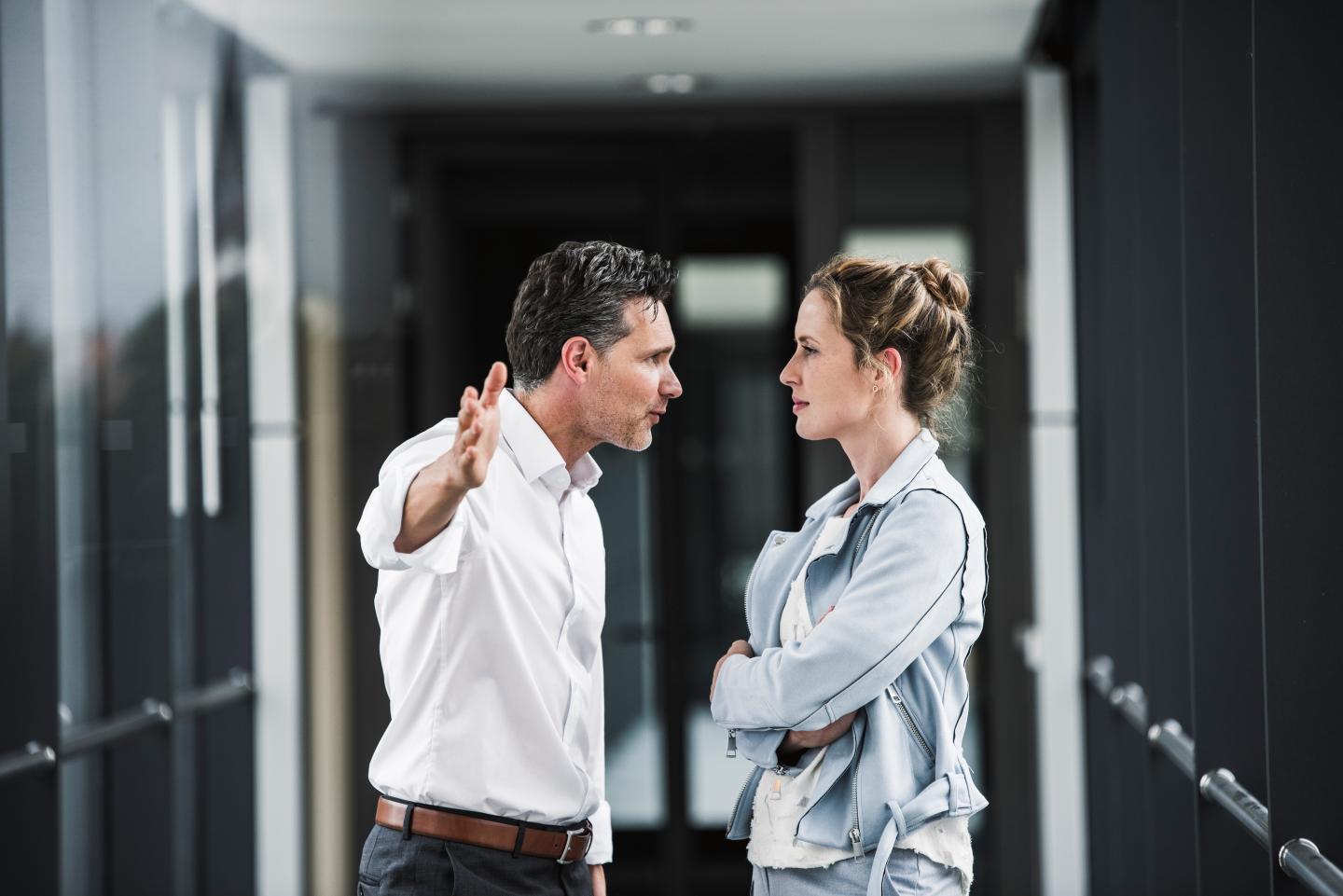 A man pictured shouting at a woman in an office setting