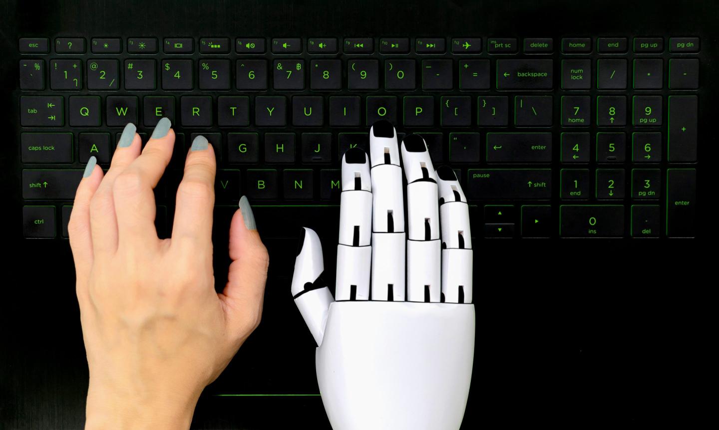 A keyboard with one human arm and one robotic arm