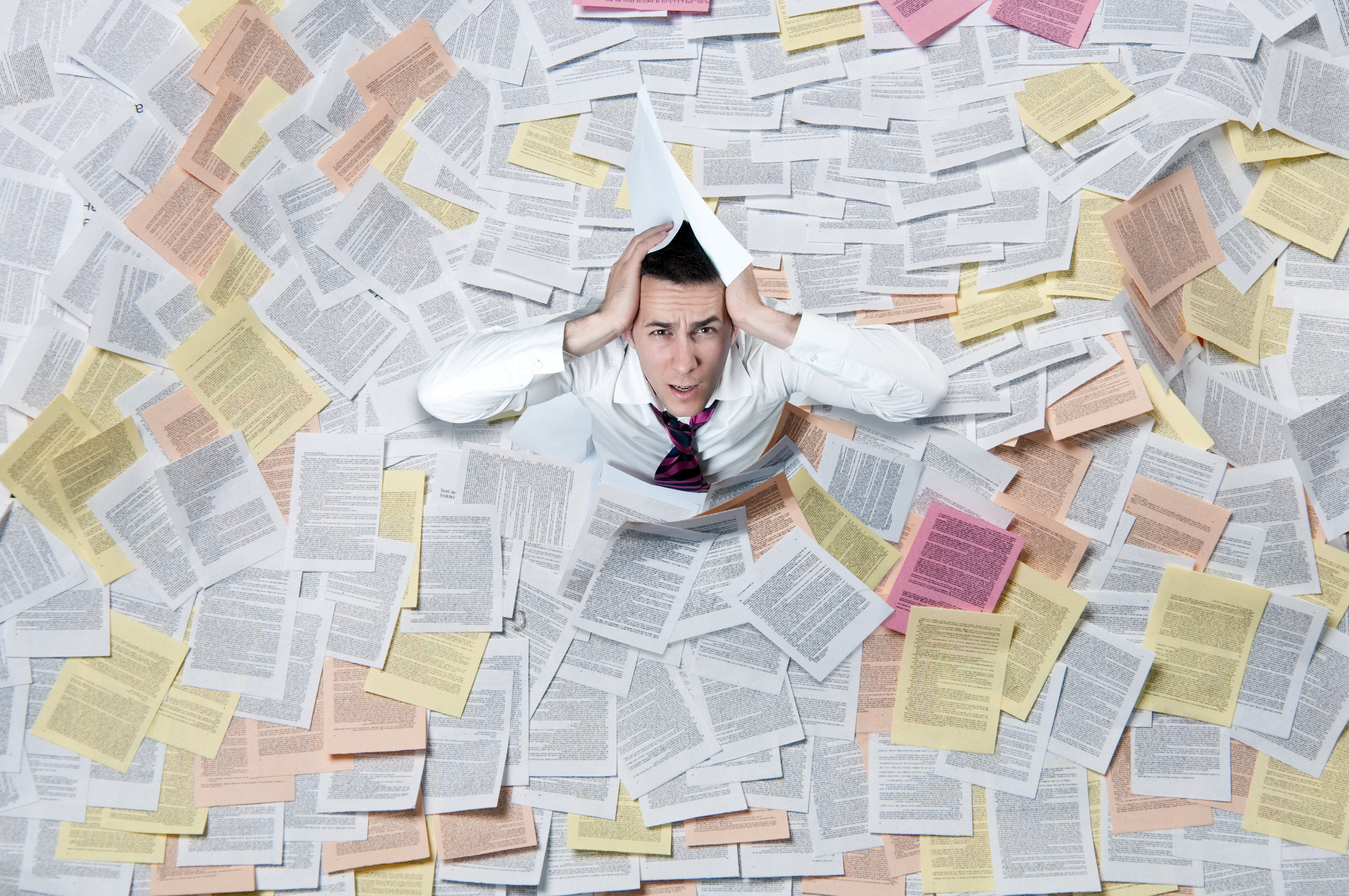 A man overwhelmed by papers and information. 