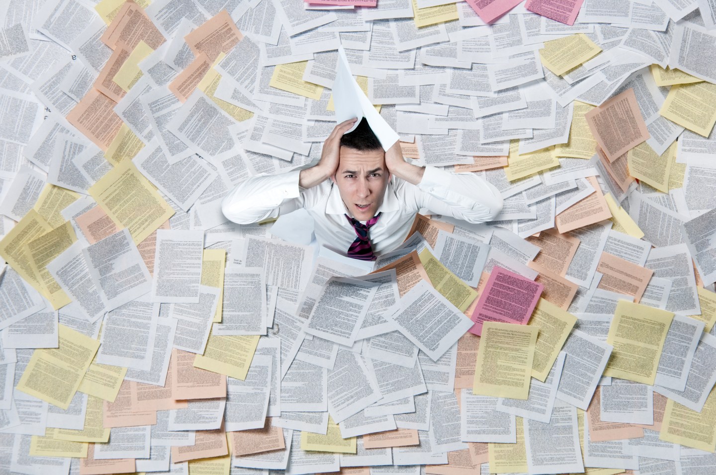 A man overwhelmed by papers and information.