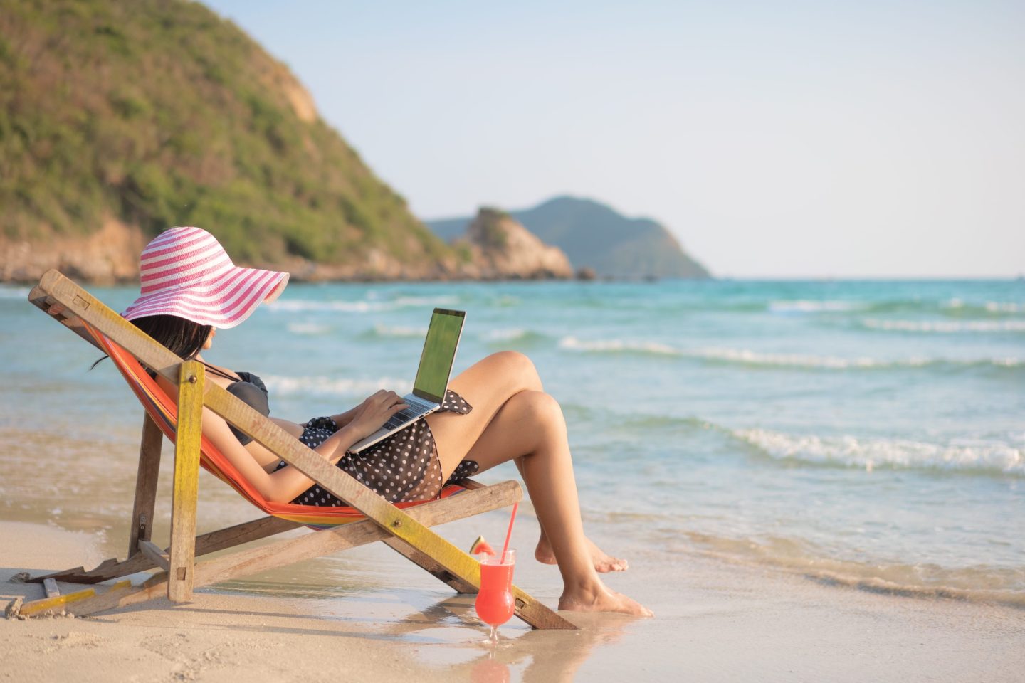 Woman on beach with a laptop
