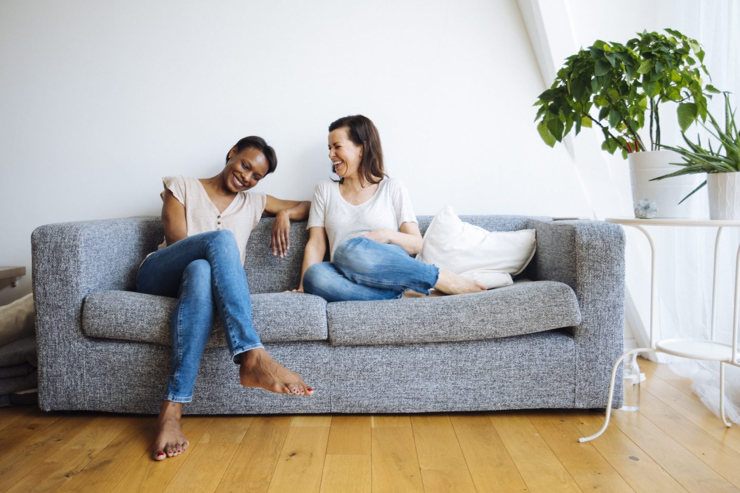 Two female friends sitting on couch