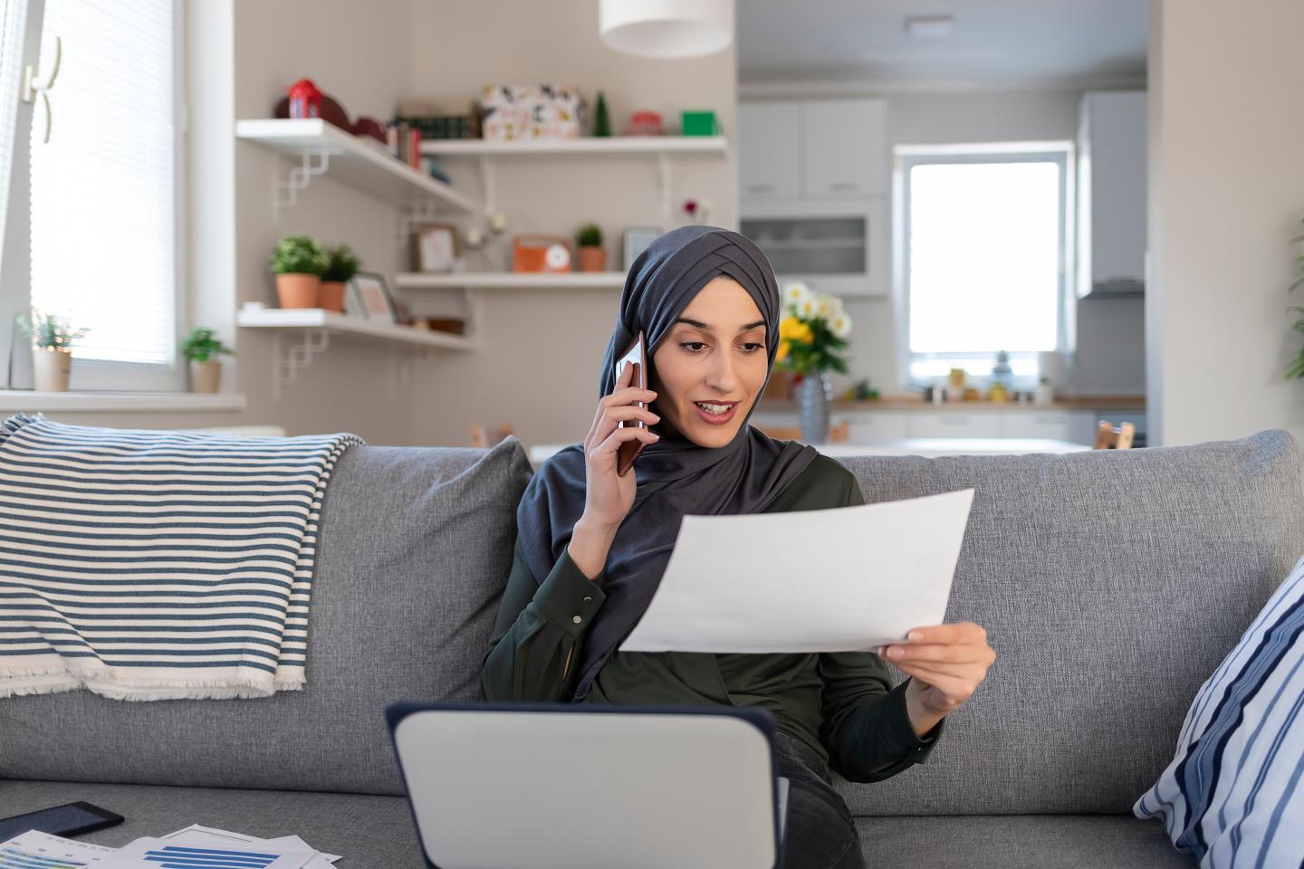 Woman in hijab talking on cellphone at home