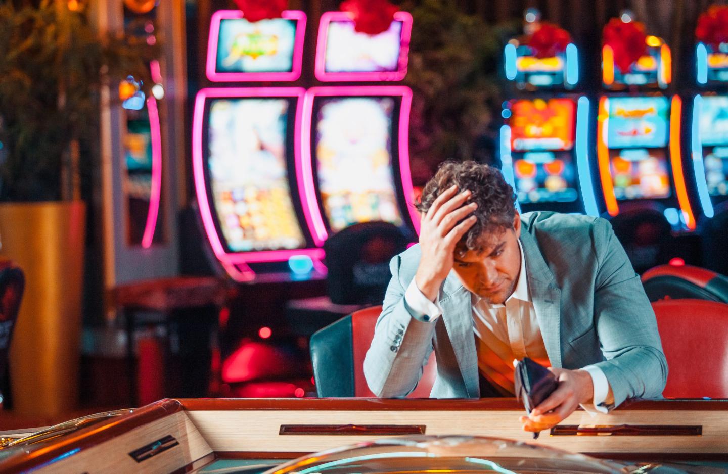 A man looking sad in a casino.