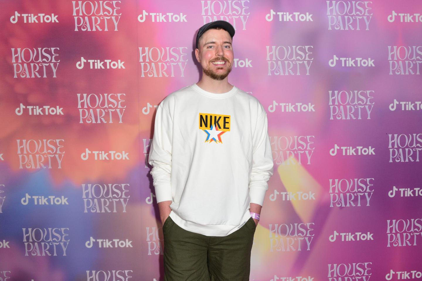 Mr Beast stands in front of a pink wall