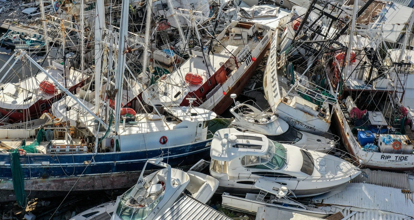 In this aerial view, boats sit atop one another in a marina in Fort Myers Beach, Florida, damaged by Hurricane Ian in 2022