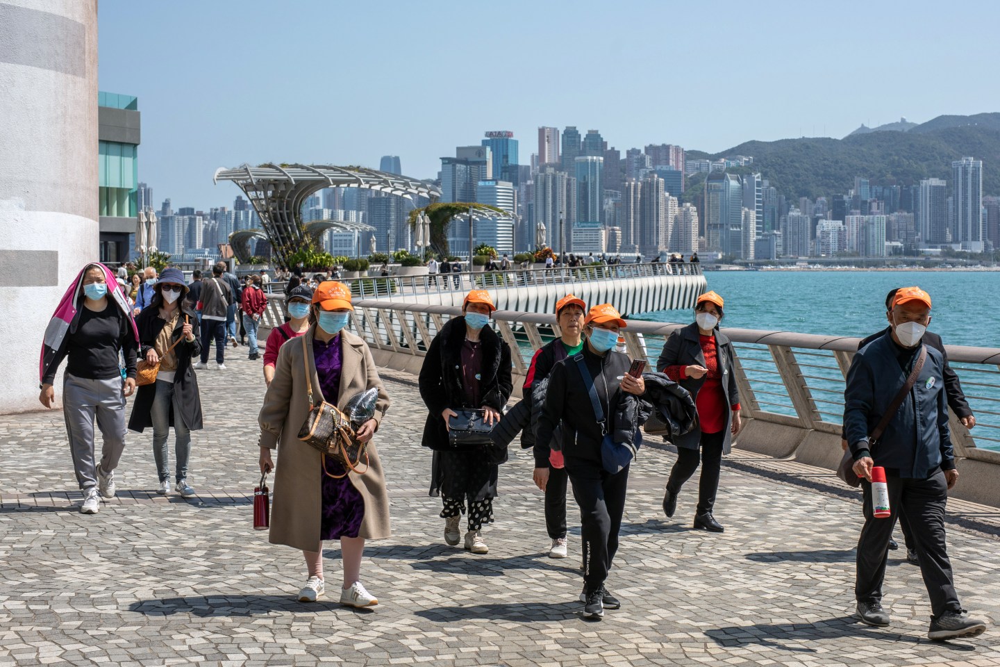 Tourists along the promenade in the Tsim Sha Tsui area in Hong Kong, on Feb. 28, 2023.