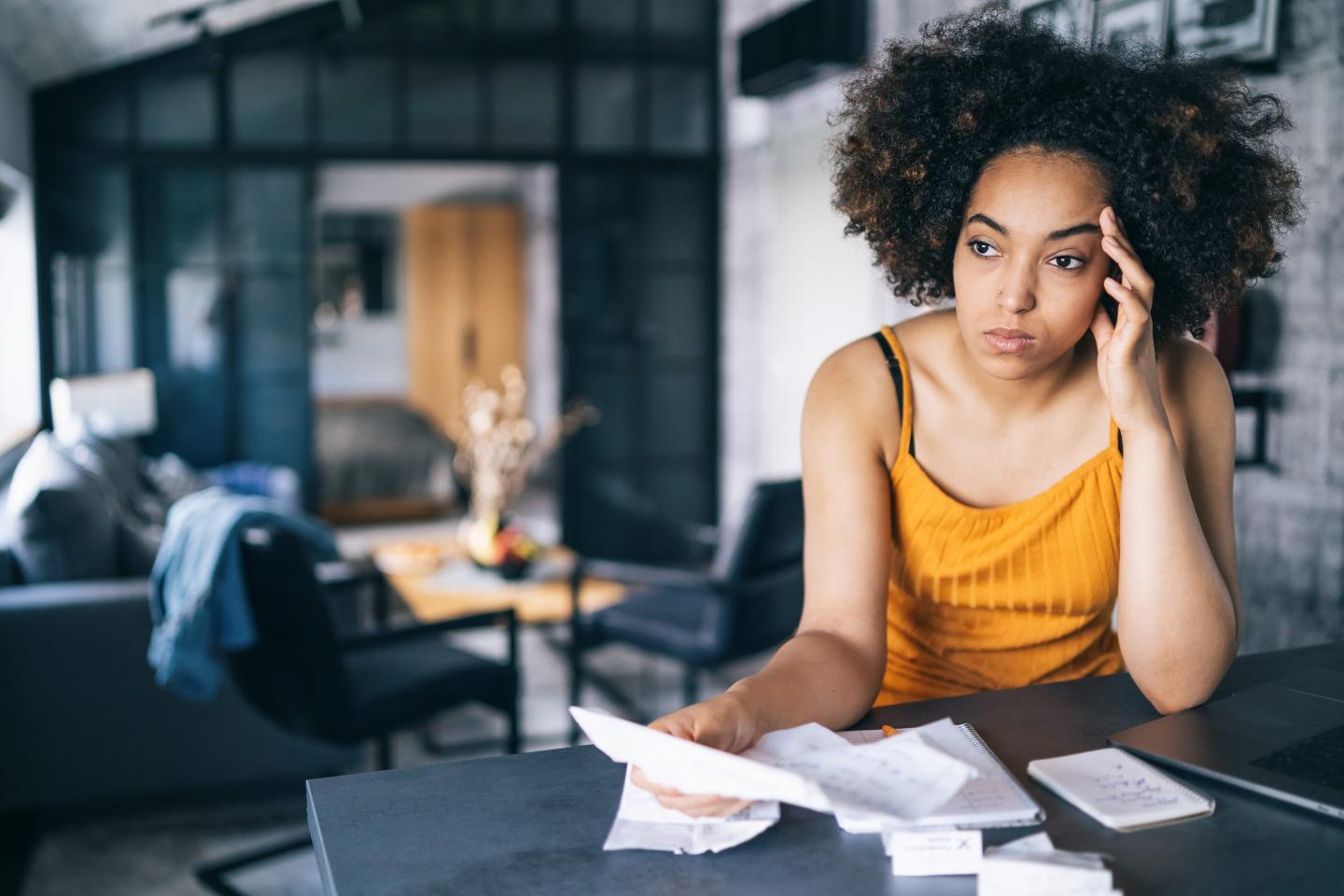 A worried person holding bills