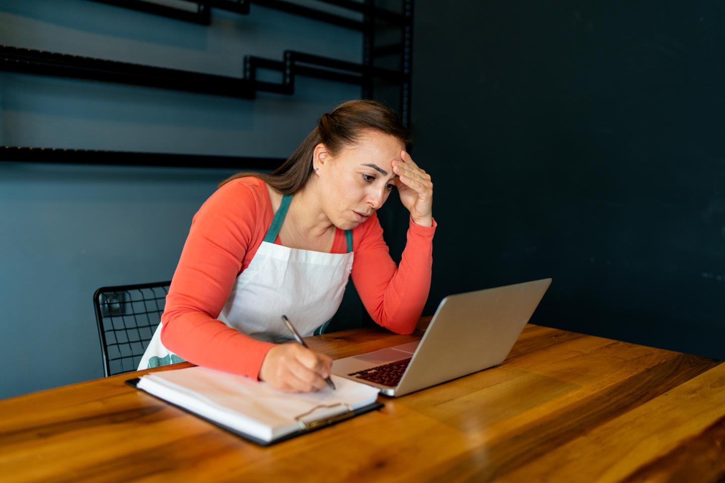 A woman staring at her computer looking worried.