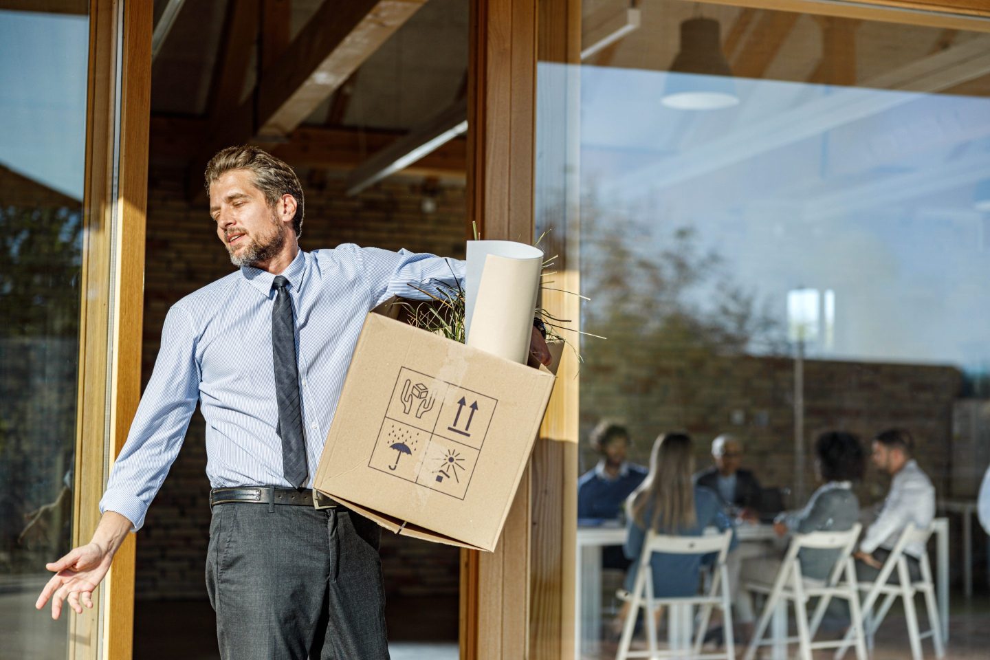 Businessman leaving his work with a box of his belongings.