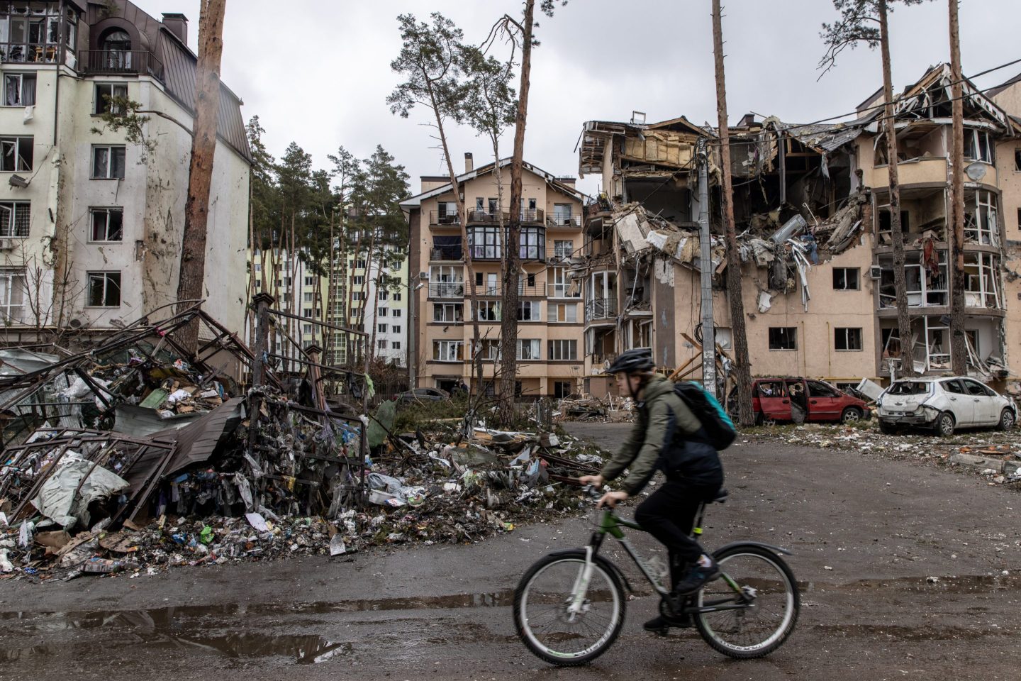 A man rides his bike past destroyed buildings on March 03, 2022 in Irpin, Ukraine.