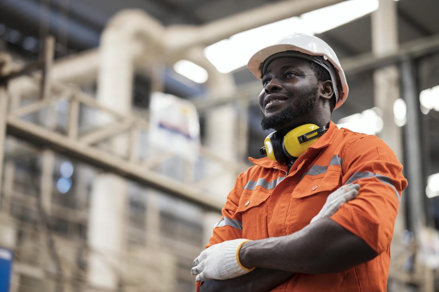 An engineer in an orange shirt smiling.