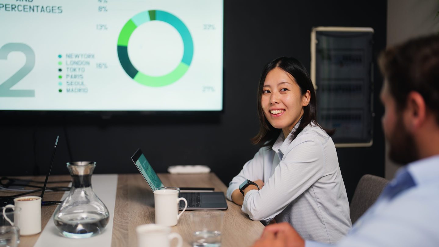 A young businesswoman is attending a business meeting in a meeting room in a modern office working space.